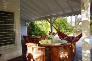 a patio with tables and chairs on a porch at Villa Van Gogh aux Aquarelles in Sainte-Rose