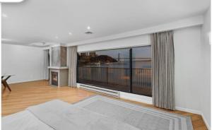 a living room with a large window and a fireplace at Panorama Hudson River view in Edgewater