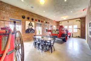 Habitación con mesa, sillas y pared de ladrillo. en Historic, Renovated Fire Station Vacation Rental! en Tulsa