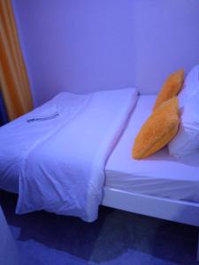 een wit bed met twee kussens erop bij Rew Apartment in Nairobi