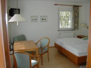 a bedroom with a bed and a table and a desk at Haus Waldfrieden in Bad Saarow