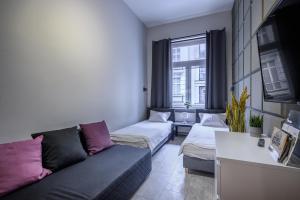 salon z dwoma łóżkami i kanapą w obiekcie Rent-Apart City Center Lodz w Łodzi