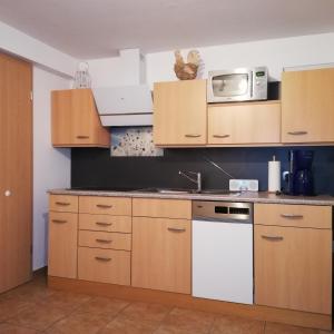 a kitchen with wooden cabinets and a white stove top oven at Ferienwohnung Blick zu den Sternen in Hohenbrück