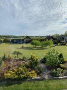 einen Garten mit einigen Büschen und Häusern auf einem Feld in der Unterkunft Osada Turystyczna Miłoszówka in Wąwolnica