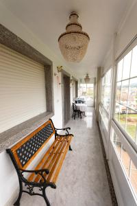 un banc installé dans un couloir avec des fenêtres dans l'établissement Alojamiento en Portonovo Playa, à Sanxenxo