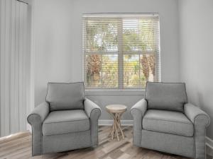 two chairs and a table in a room with a window at Blue Mountain Beach Condominium 102 by Newman-Dailey in Santa Rosa Beach