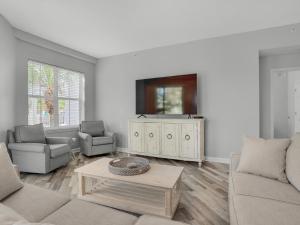 a living room with a couch and a tv at Blue Mountain Beach Condominium 102 by Newman-Dailey in Santa Rosa Beach