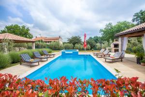 a pool with chaise lounge chairs and a patio at Villa Medvidići in Rajki