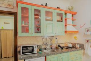 a kitchen with green cabinets and a sink and a microwave at The Best Nest in Rome