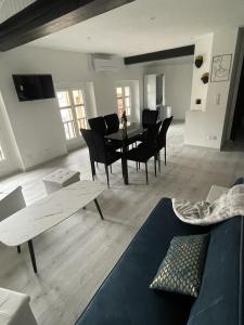Babiloc Moderne à Riez في ريز: غرفة معيشة مع طاولة سوداء وكراسي