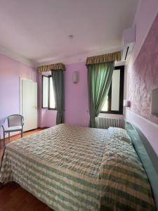 - une chambre avec un grand lit, des murs violets et des fenêtres dans l'établissement Hotel divino Amore, à Bagnoregio