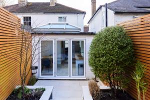 przedłużenie do domu z przesuwanymi szklanymi drzwiami w obiekcie The Elmbridge Getaway - Glamorous 2BDR with Garden w Londynie