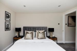 sypialnia z dużym białym łóżkiem z 2 lampami w obiekcie The Elmbridge Getaway - Glamorous 2BDR with Garden w Londynie
