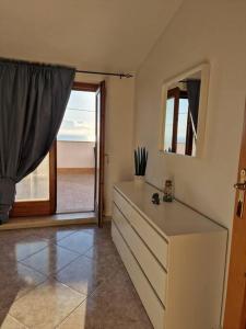 a room with a dresser with a mirror and a window at Home Belvedere in Belvedere Marittimo