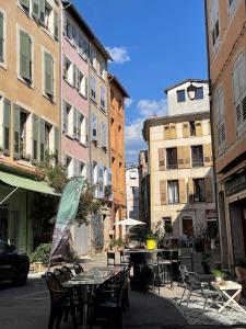 an outdoor patio with tables and chairs and buildings at Babiloc Moderne à Riez in Riez +6 photos