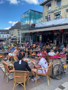 a group of people sitting at tables outside a restaurant at Hotel Montagna Delmondo in Valkenburg