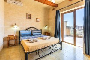 a bedroom with a bed with towels on it at Ta Debora 3 bedroom Villa with private pool in Xagħra +16 photos