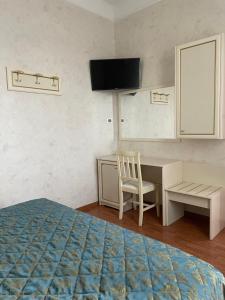 1 dormitorio con escritorio, 1 cama y ordenador en Hotel divino Amore, en Bagnoregio