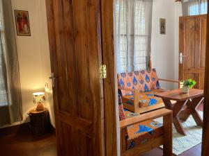uma porta para um quarto com uma cadeira e uma mesa em Camp Bastian Mikumi em Mikumi