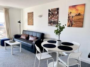 Cosy Egyptian Inspired Apartment Northampton في نورثامبتون: غرفة معيشة مع أريكة وطاولة وكراسي