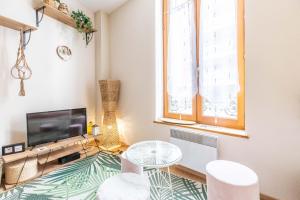 a living room with a tv and a table and chairs at Evasion Centre-ville 2 à 8 personnes in Clermont-Ferrand