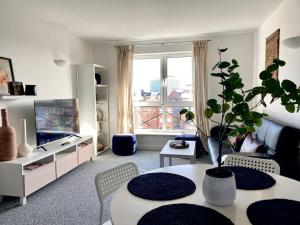 Cosy Egyptian Inspired Apartment Northampton في نورثامبتون: غرفة معيشة مع طاولة فيها زرع