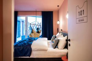 una camera da letto con letto, lenzuola e cuscini bianchi di Sport Hotel Passo Carezza a Vigo di Fassa