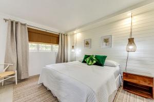 a bedroom with a white bed with green pillows at The Palms Resort in Saint James