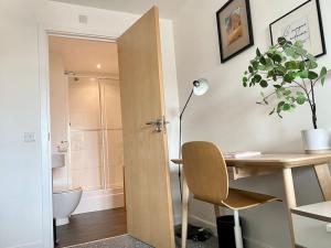 Cosy Egyptian Inspired Apartment Northampton في نورثامبتون: مكتب وكرسي في غرفة مع حمام