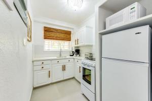 a kitchen with white cabinets and a refrigerator at The Palms Resort in Saint James