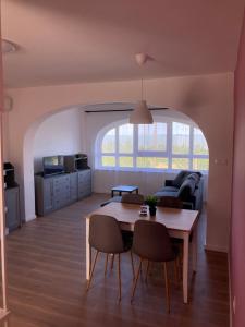 uma sala de estar com uma mesa e um sofá em Paphegy Apartman em Balatongyörök