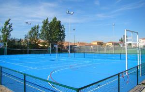 Una pista de tenis azul con una red. en MobileHome 8 Personnes avec Clim situé au Camping l'Elysée Grau du roi Vagues Océanes By CapFun en Le Grau-du-Roi
