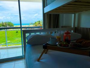 ein Schlafzimmer mit einem Bett und einem Tablett mit Essen auf einem Tisch in der Unterkunft Vista mar incrível pertinho do Beach Park in Aquiraz