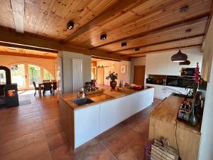 a large kitchen with wooden ceilings and a counter top at PRIVATE VILLA - TENNISCOURT in the moutains 19 GUESTS Cairo Montenotte VILLAITALY EU in Cairo Montenotte