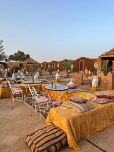 un groupe de tables et de chaises dans un désert dans l'établissement Rêves de désert, à M'Hamid El Ghizlane