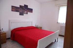 una camera con un letto con una coperta rossa di Appartamento da Luca a Calasetta
