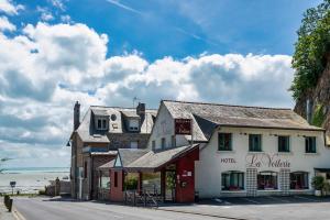 a building on the side of a street with the ocean at Hotel La Voilerie Cancale bord de mer in Cancale