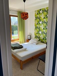 a bedroom with a bed and a window and a chair at Osada Turystyczna Miłoszówka in Wąwolnica +38 photos