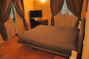 a bedroom with a bed and a desk with a television at B&B Al Canto del Cavour in Pistoia