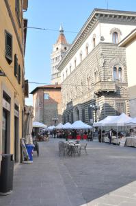 a street with tables and umbrellas in front of a building at B&B Al Canto del Cavour in Pistoia