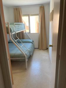 a bunk bed in a room with a window at Piso Isla Cristina Punta del Caimán in Isla Cristina