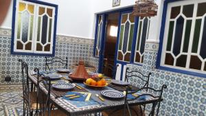 una mesa en una habitación de color azul y blanco en Taghart, la belle demeure, en Essaouira