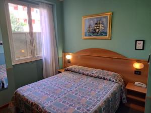 een kleine slaapkamer met een bed en een raam bij Hotel Azalea in Baveno
