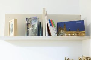 a shelf with books and pictures on it at SESAR Padrón VUT-CO-001865 in Padrón