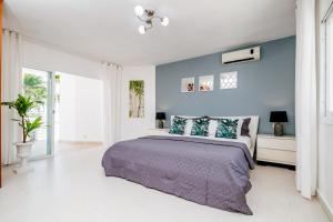a bedroom with a bed and a blue wall at Beachfront Punta Cana Condo for Rent - Ocean View, Private Terrace, and BBQ in Punta Cana