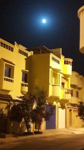 a large yellow building with a moon in the sky at Taghart, la belle demeure in Essaouira