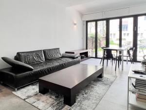 耶路撒冷的住宿－2 BR next to Old City with Patio by FeelHome，客厅配有黑色沙发和桌子