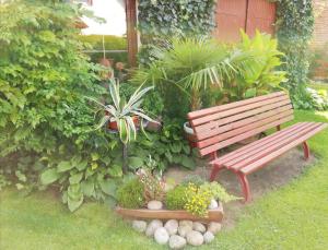 un banco de madera en un jardín con plantas en Ferienwohnung Blick zu den Sternen, en Hohenbrück