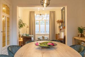 a dining room table with a bowl of flowers on it at Sweet Alice Holiday Home in Ieper