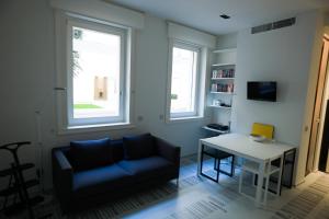 a living room with a blue couch and a table at Stylish Mini in the Heart of Milano in Milan